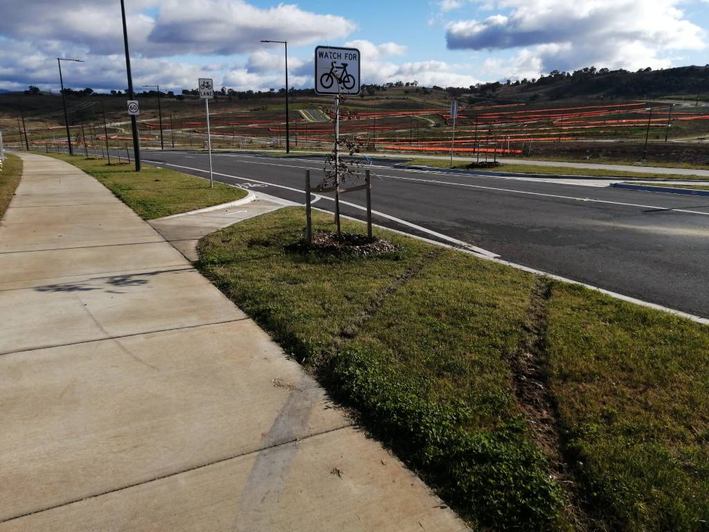 Vehicles are driving on the verge destroying the footpath and grass. Sculthorpe Ave, Road 01, Whitlam, Molonglo Valley, 8 June 2022.